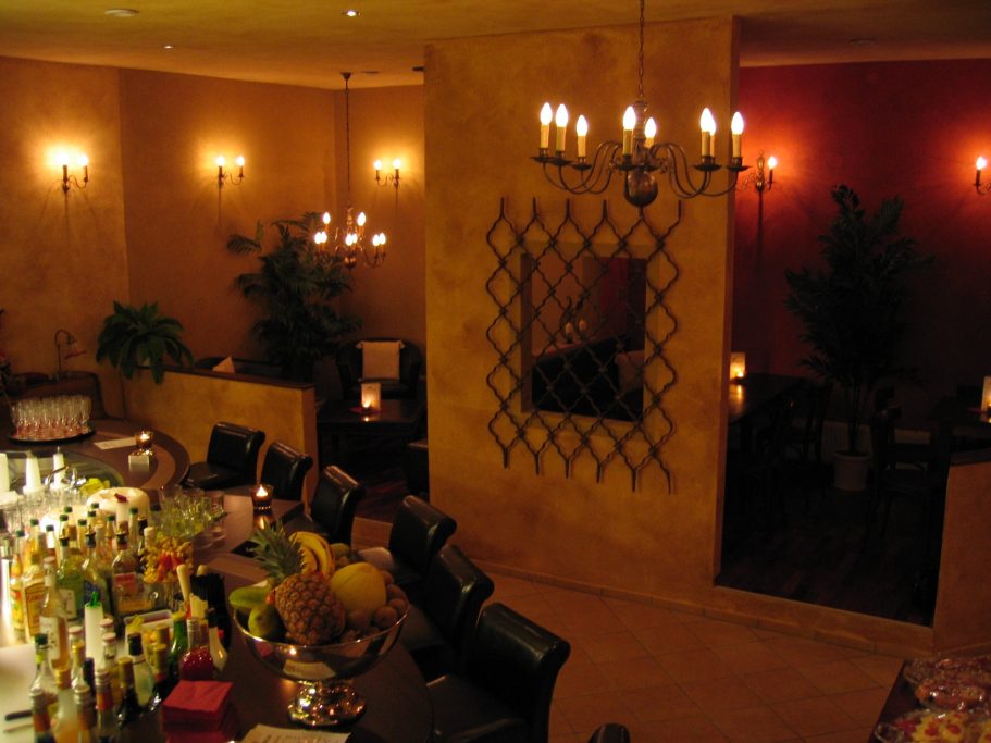Warme Beleuchtung und dekorative Details im Innenraum der Cocktailbar Mákaá
