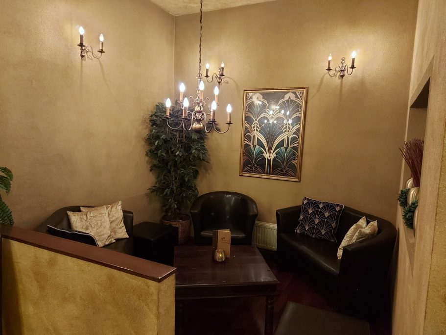 Gemütlicher Sitzbereich mit dunklen Sesseln in der Cocktailbar Mákaá